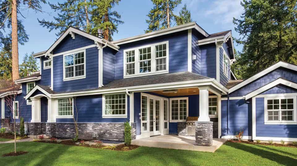 A cool home with navy blue exterior and a lawn