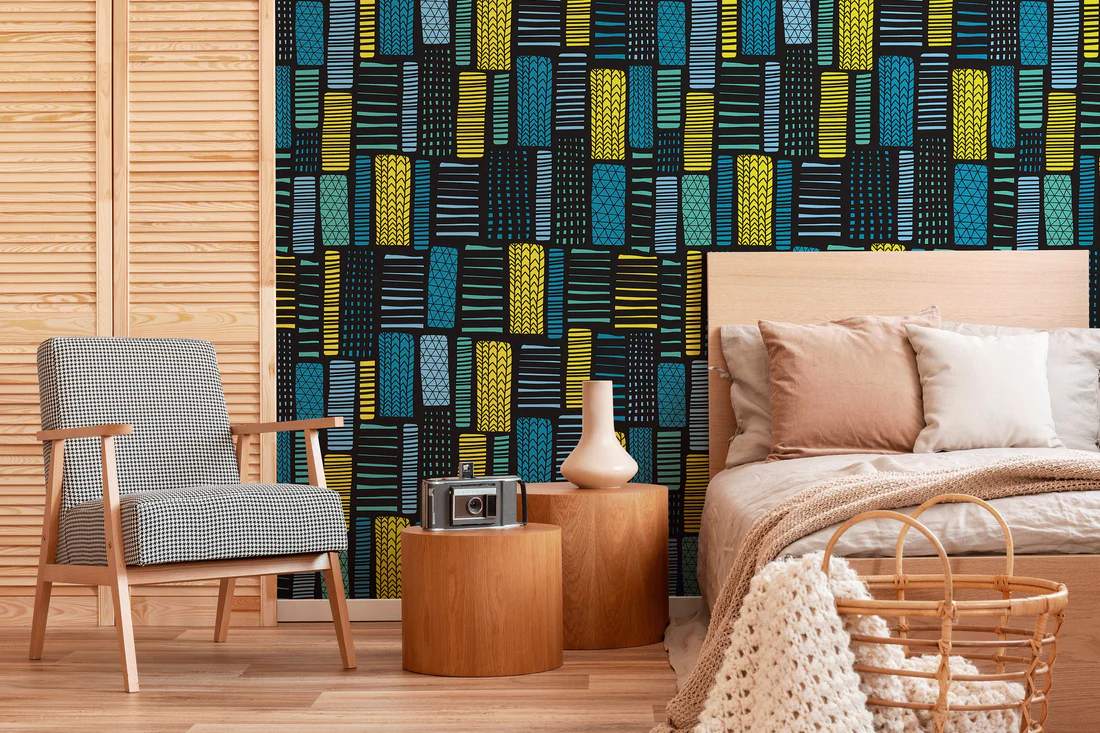 blue and black tribal decor wallpaper in a room with a bed, chair and table