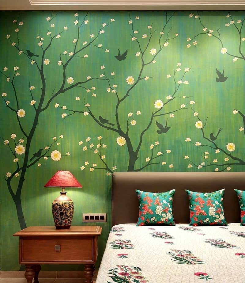 A green bedroom wall paint design idea with imprints with a bed and lamp