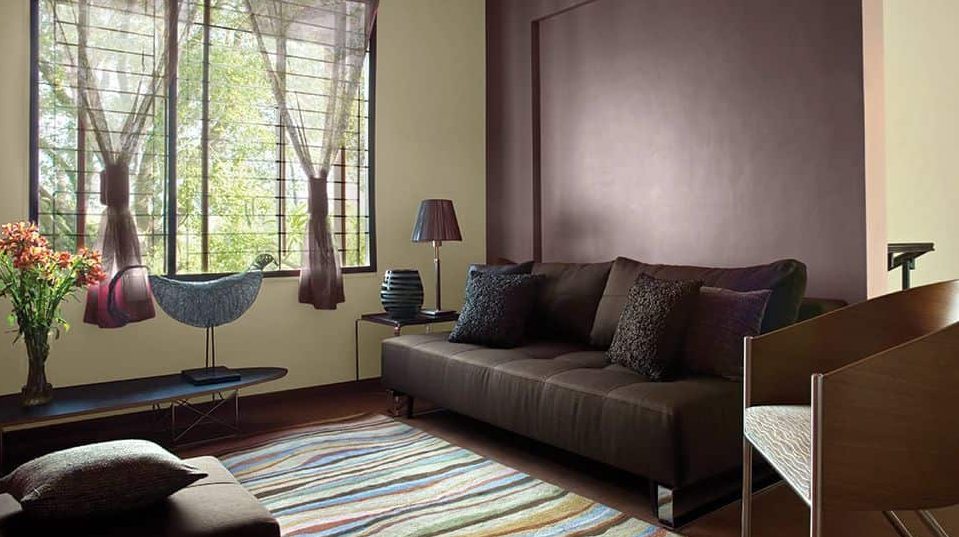 A hall in brown colour with sofas and rug