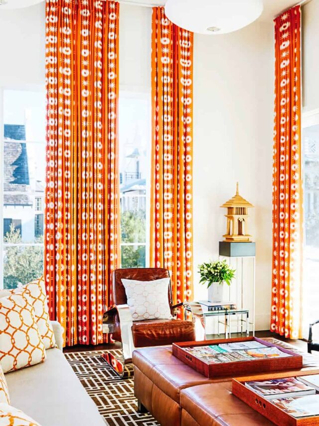 orange coloured patterned ceiling to floor curtains in a living room with leather sofa set