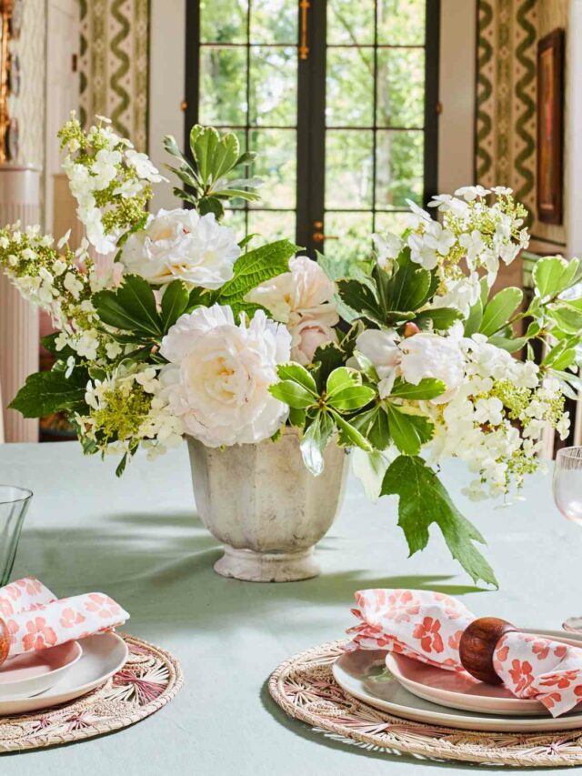 floral display on the dining table with lush white roses in a white ceramic vase
