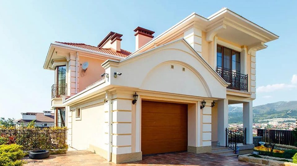 A home with a peach and white exterior and trees