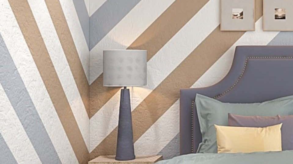 A bedroom wall with stripe wall paint design idea along with a bed and a lamp