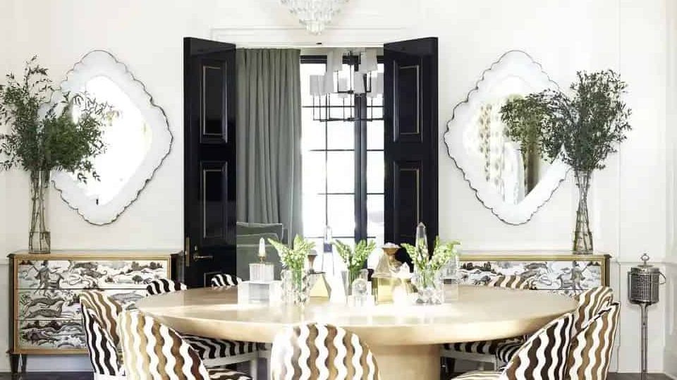 A white dining area with dining table and mirrors