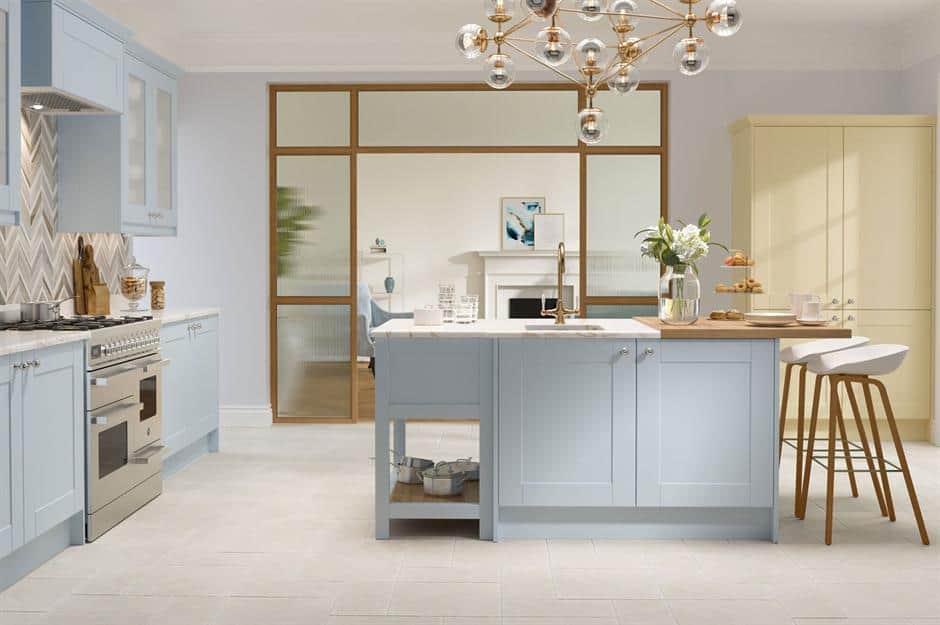 blue cooking ،e with a chandelier, cabinets and appliances