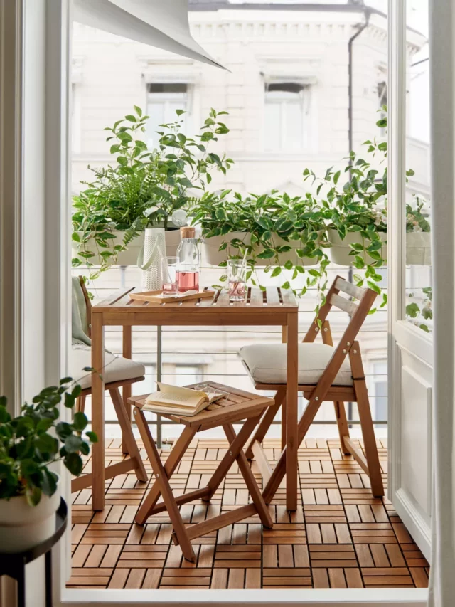 small balcony garden idea with a seating corner with wooden furniture and hanging plants