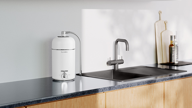 drinking water filter in a kitchen with black counter tops, sink and taps