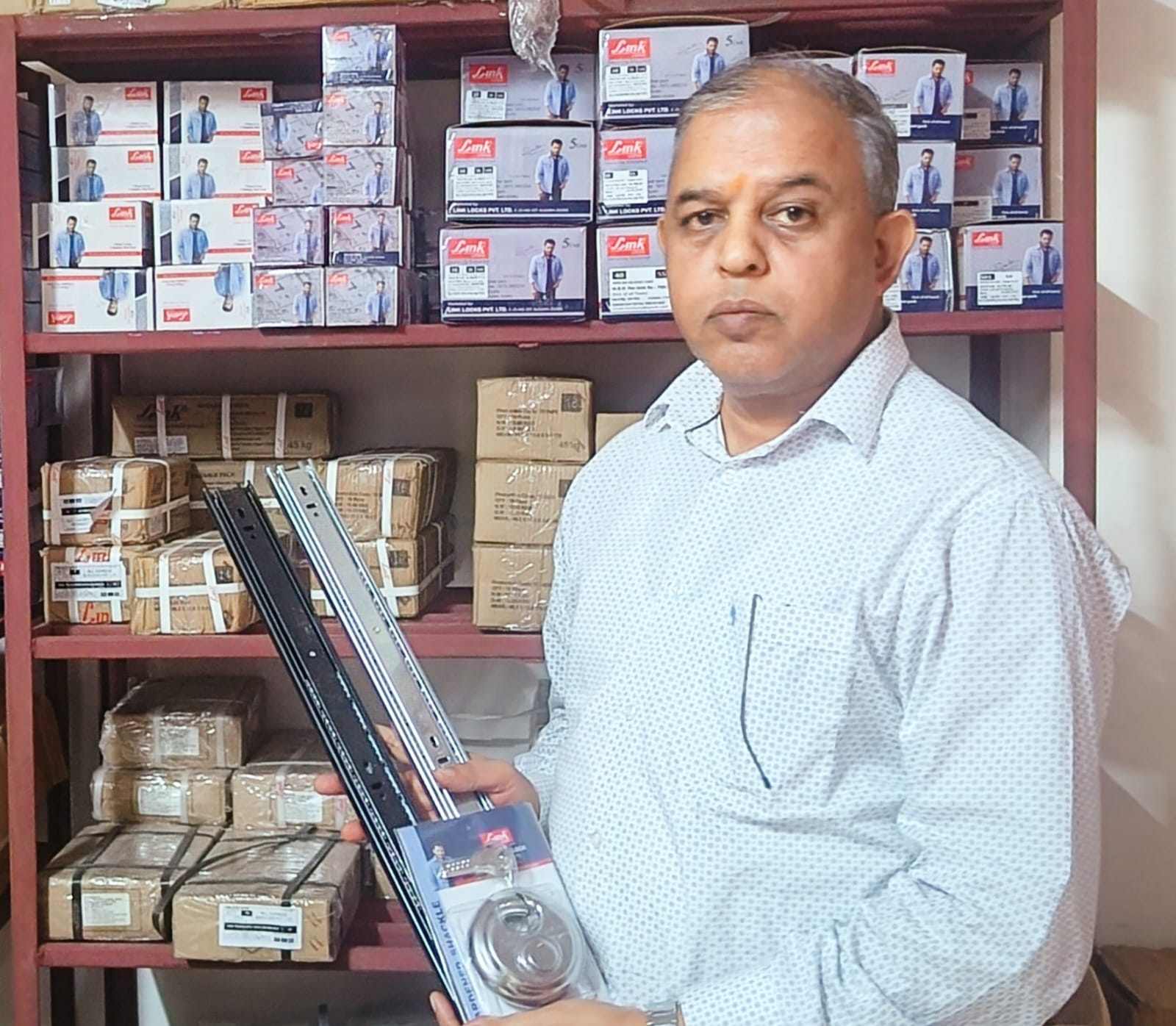 Mr. Surendra Singh holding link locks products in his office