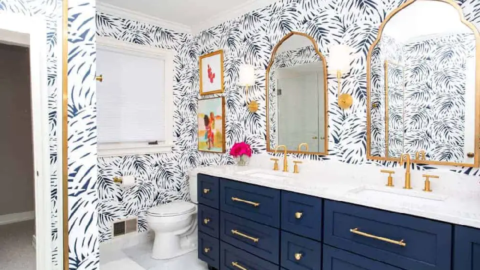 white wallpaper design in a bathroom with blue cabinets