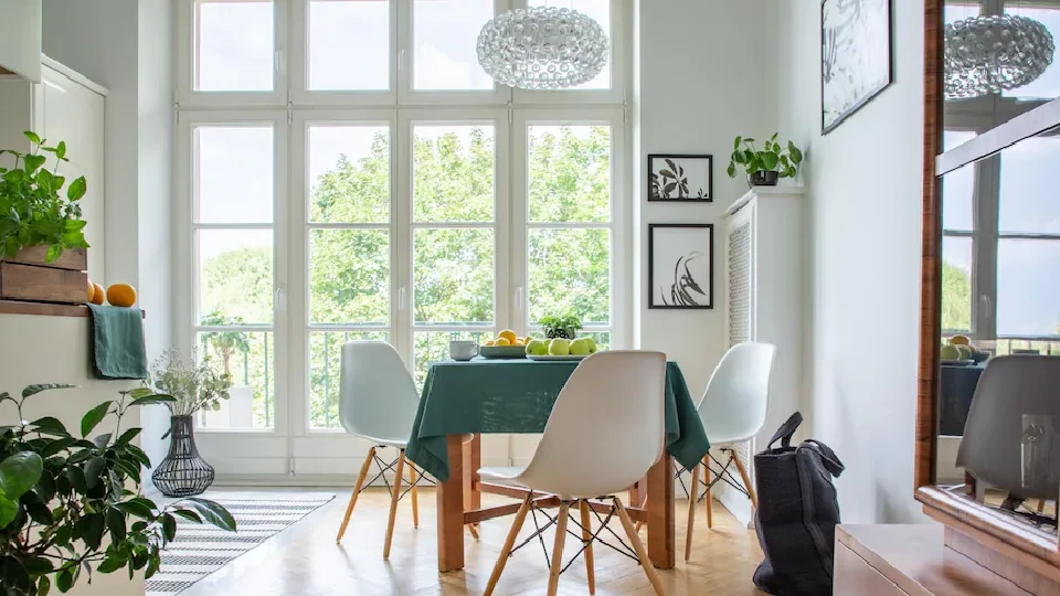 french doors in a dining room with a dining table and chandelier