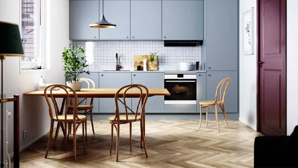 Single row gallery kitchen design interior having pendant light, chairs, blue coloured cabinets