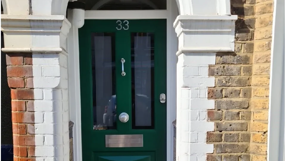 green wooden Victorian door in a home