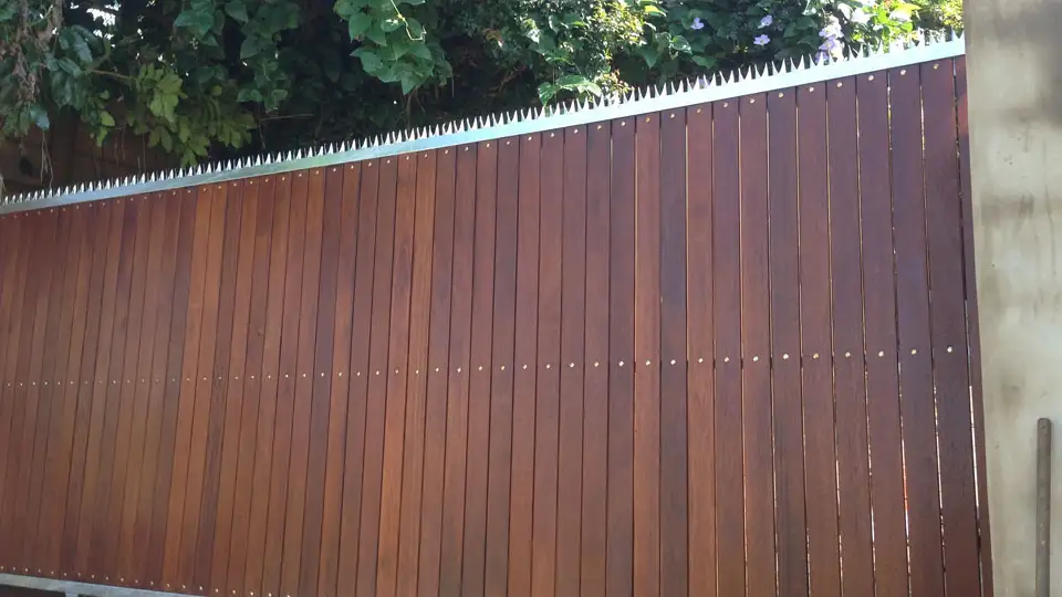 Slated wooden sliding modern gate with stainless steel grill