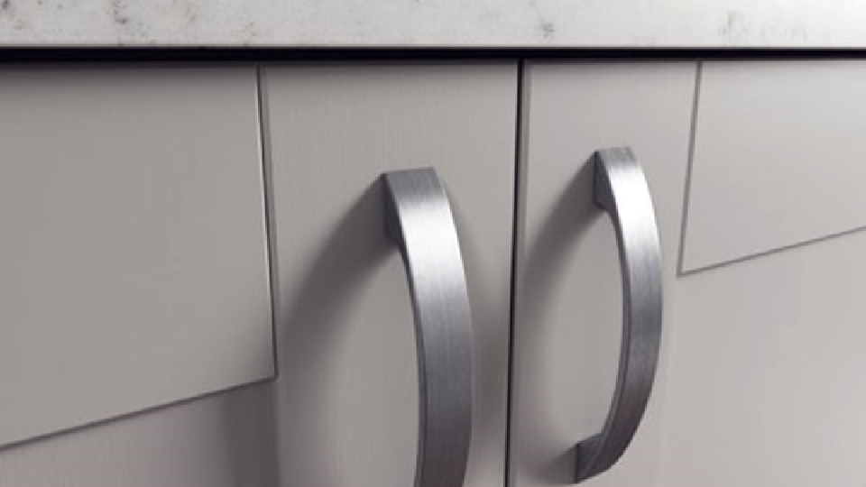 Chrome-finish bow kitchen handle on grey cabinet