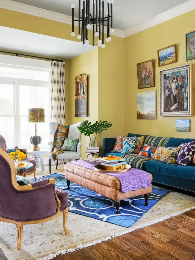 Yellow living room with yellow walls and white ceiling, chandelier, blue and purple sofa with pink center table