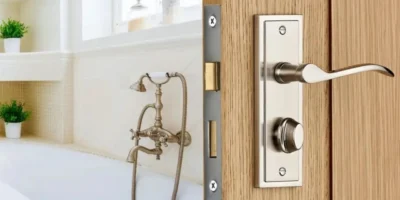 a metal finished mortise doorknob with lock over a wooden door for bathroom