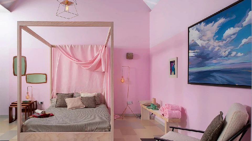 Powder pink coloured bedroom with a huge blue painting offering contrast