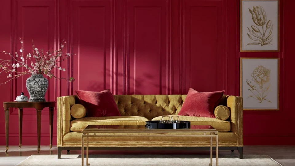 a scarlet red coloured living room contrasted by yellow sofa 