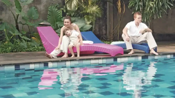 Couple sitting on REHAU furniture by the pool