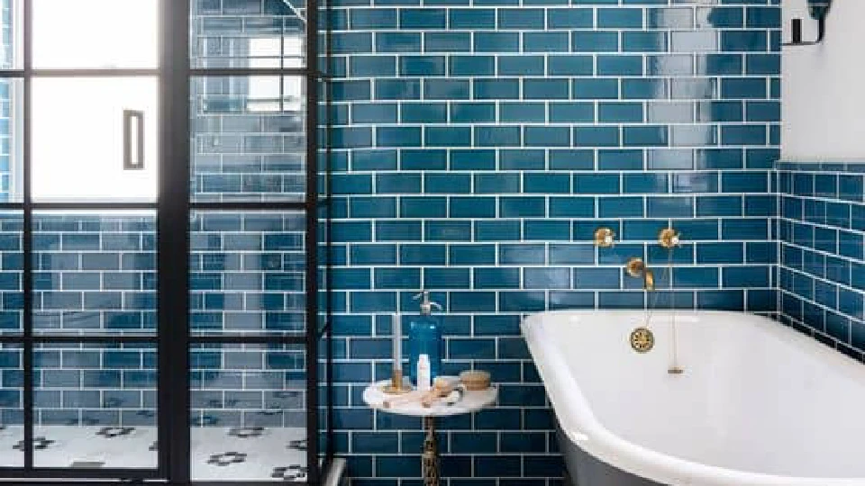 Blue bathroom tiles with white bathrub