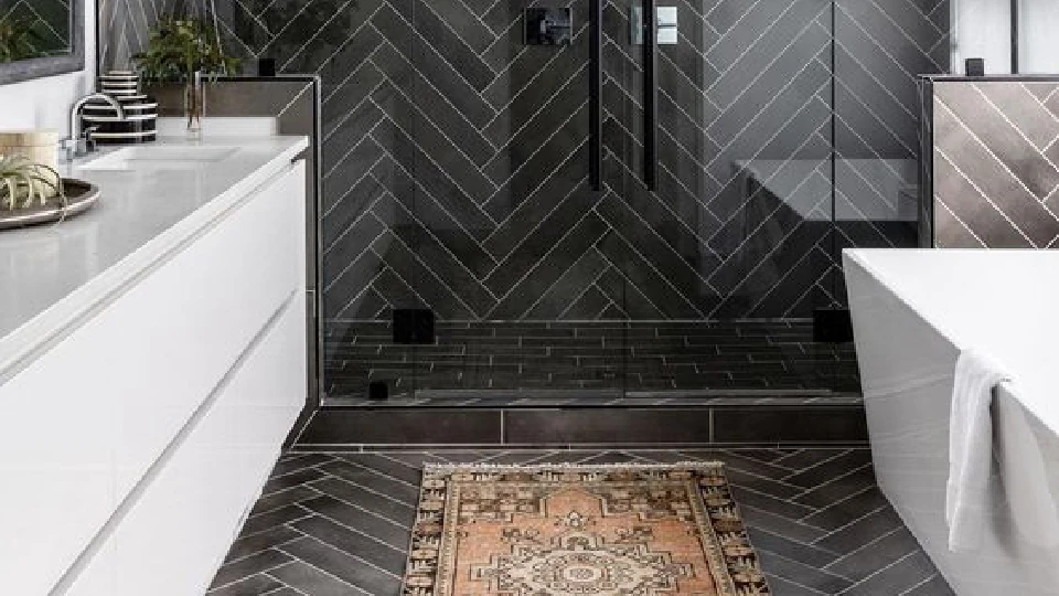 grey tiles in a bathroom with mats and white cabinets