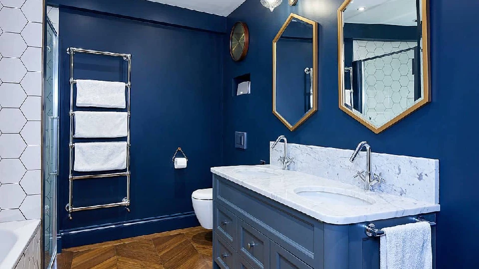 blue bathroom with blue cabinets, wall mirrors