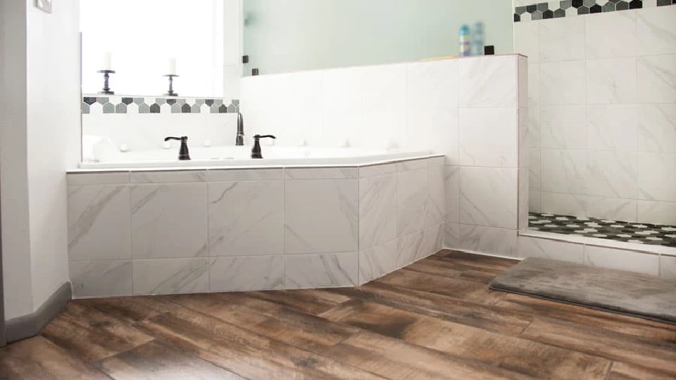 white bathtub in a bathroom with brown wooden style flooring