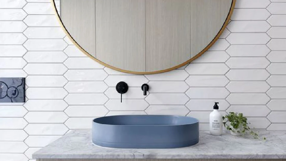 white wall with round wall mirror and blue oval wash basin