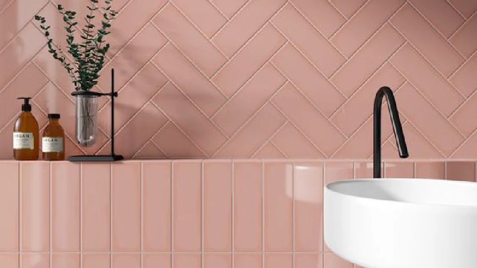 Pink walls in a bathroom and white wash basins