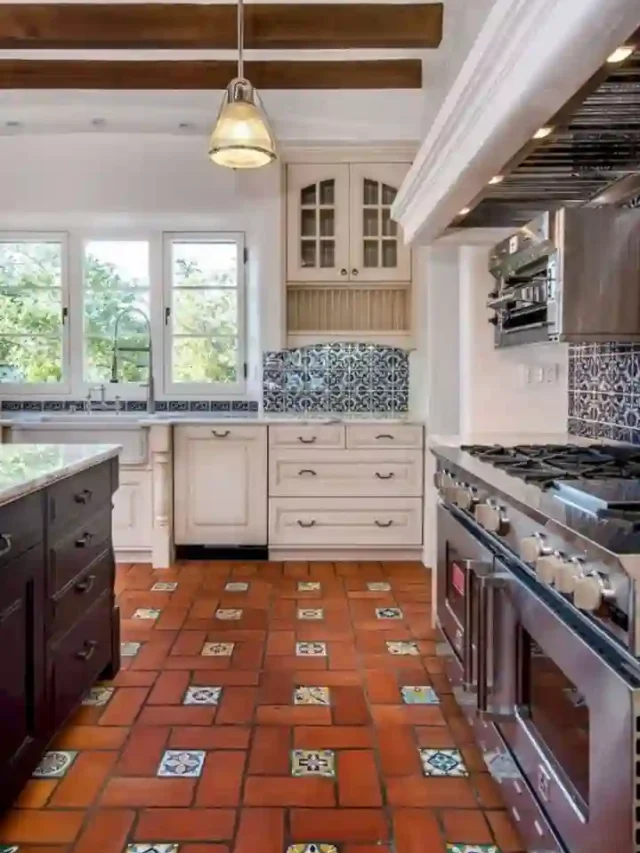 A moroccan kitchen with patterened floor tiles, terracota wall tiles and hanging lights