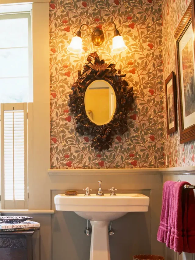 yellow bathroom with floral wallpaper in the background an antique mirror hanging on the wall