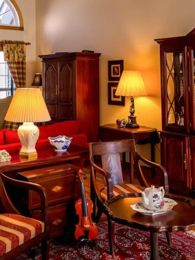 living room with vintage furniture, lamp on wooden stool and shelves, wooden almirah in the corner