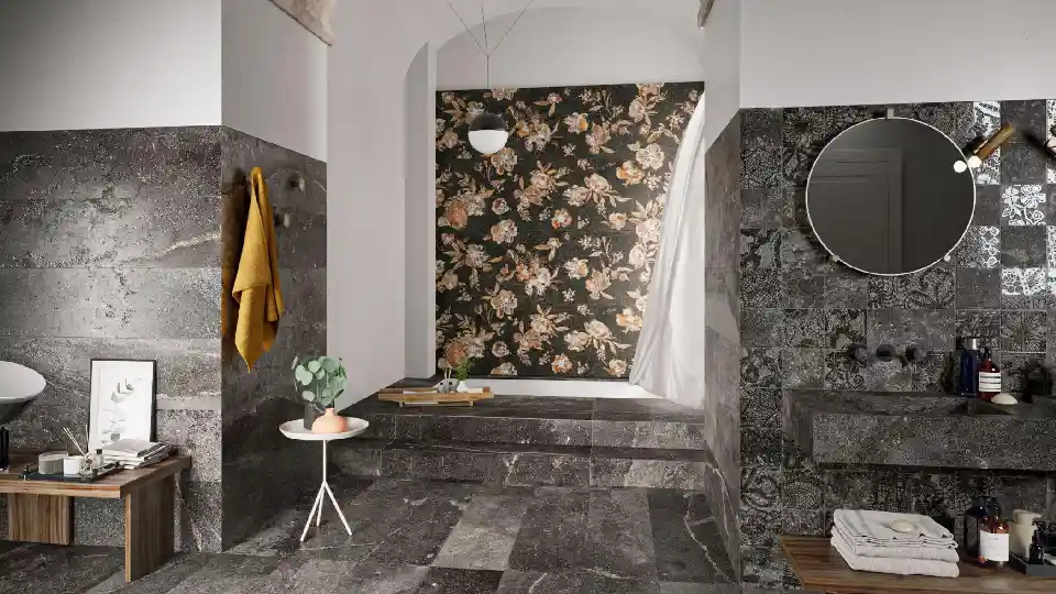 washroom setting with dark grey rock tiles textured wall, archway in the middle, round mirror and other bathroom accessories like liquid soap dispenser, towels, etc.