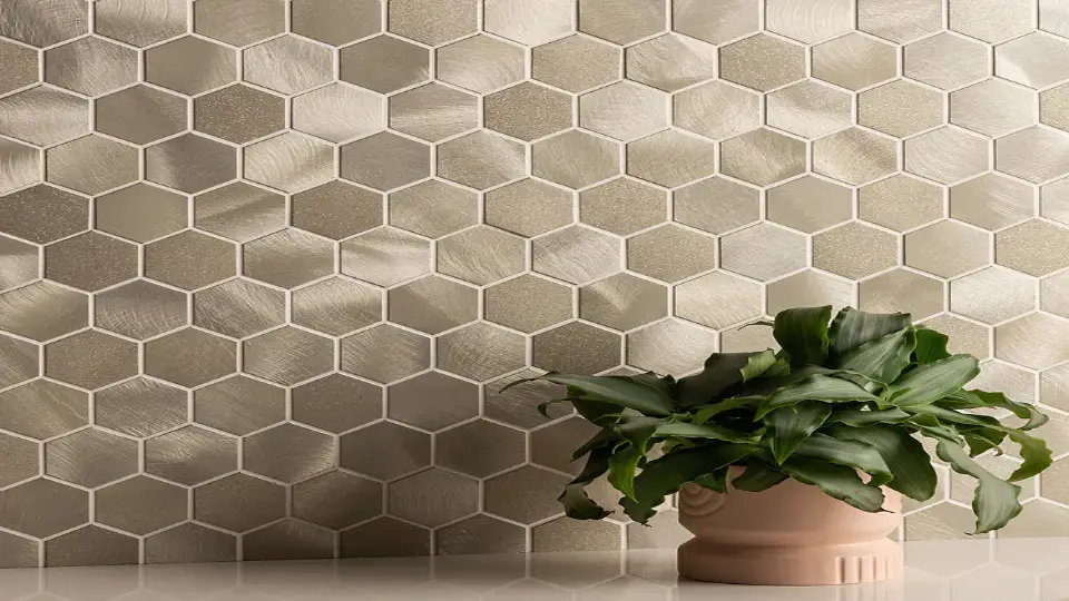 Metallic tiles in hexagon shape and a plant with green leaves