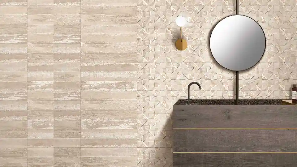 beige tiles on bathroom wall, wash basin on a wooden cabinet, wound mirror on the wall