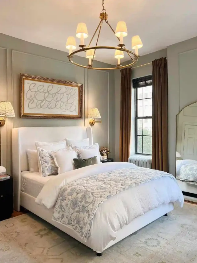 Bedroom with a painting behind the bed, hanging light and soft green walls