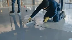 A man applying epoxy resin flooring price per square foot