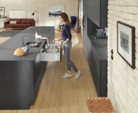 Blum under sink cabinet storage solution in a kitchen with a woman standing in front of it