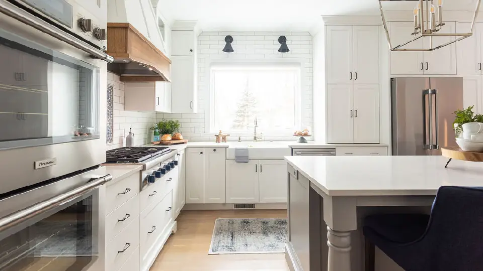 modern white kitchen with island, appliances and wooden flooring