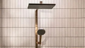 Gold-toned Hansgrohe Raindance Alive shower with square overhead rain shower and round handheld shower, mounted on tiled bathroom wall.