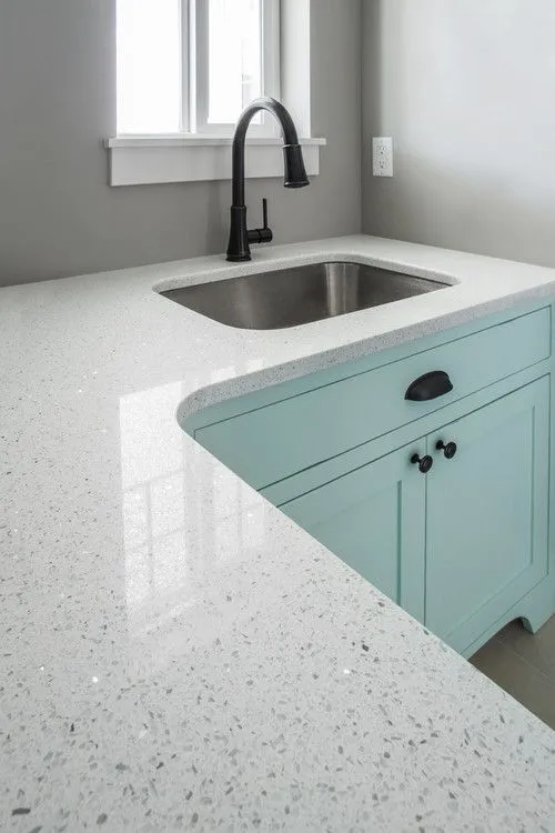 white textured quartz kitchen countertop design with light blue cabinets. 
