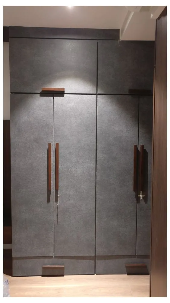 golden cylindrical handles in vertical and horizontal arrangements on a white wardrobe