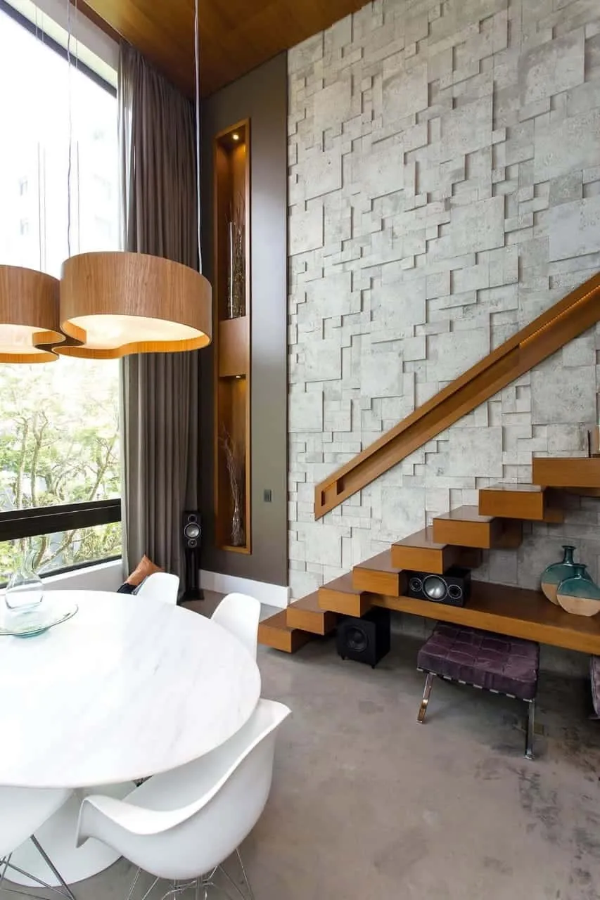 a neutral wall design with stone by the wooden stairway