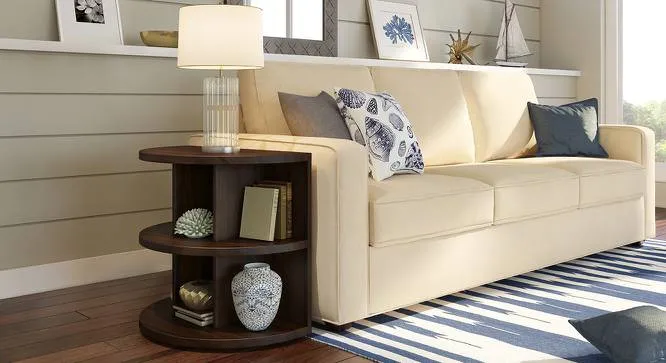 dark brown small curved shelf beside cream coloured sofa, lamp, room setting