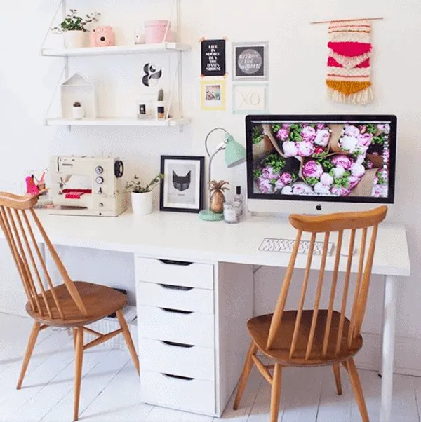 white computer table with drawers, two wooden chairs, decorated room