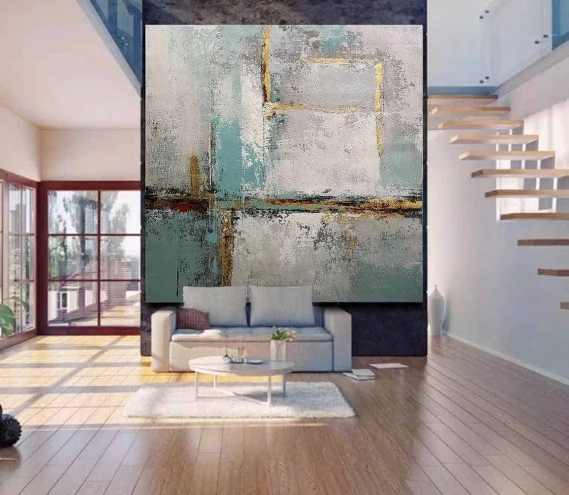 large abstract blue painting accent wall in a living room with wooden floors and a sofa