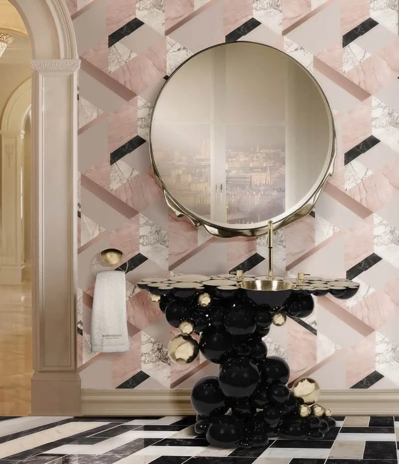 black sink with a round mirror with pink walls