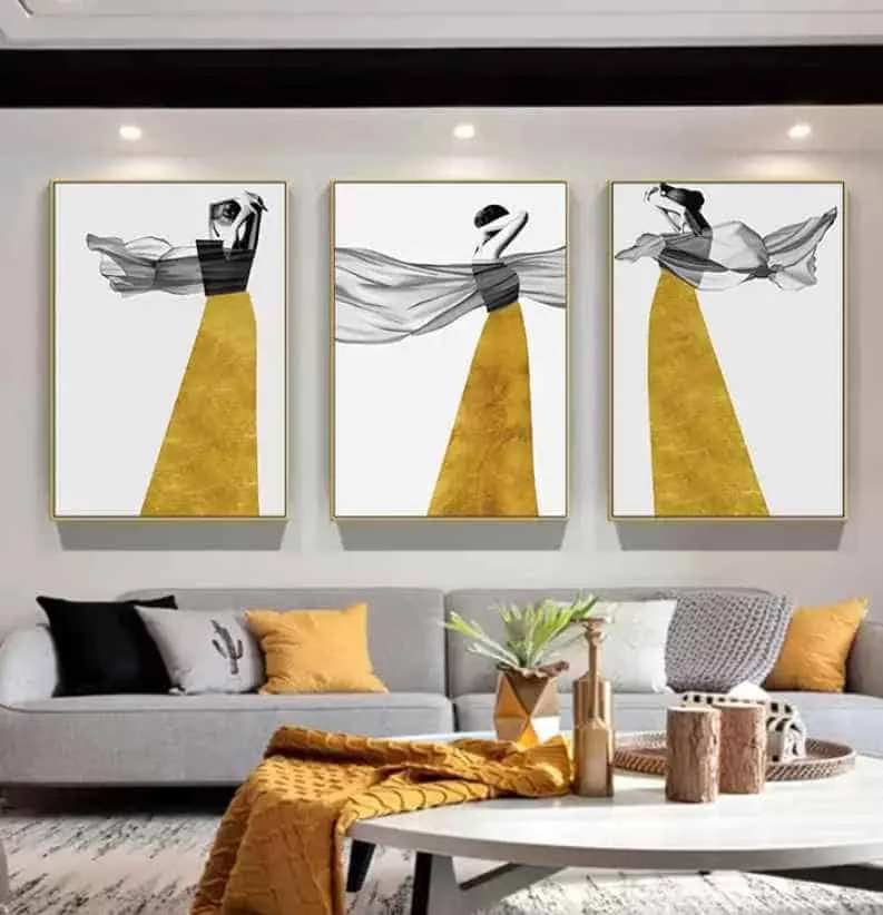 yellow statement paintings in a living room with grey sofa and a table