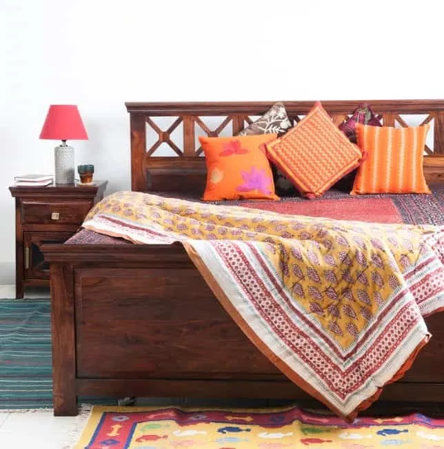 brown wooden frame bedroom furniture, colourful pillows and sheets, side table, nightlamp